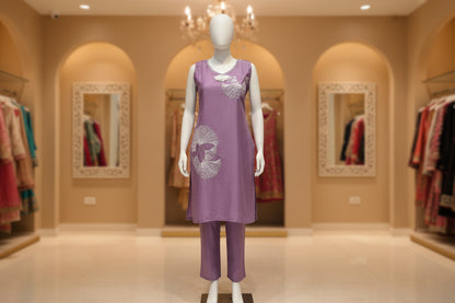 Purple top with white embroidery on a mannequin against a plain background
